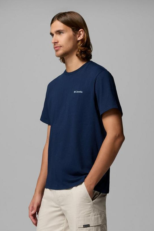 Person wearing a navy blue Columbia t-shirt on a gray background