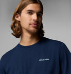 Man wearing a navy blue Columbia t-shirt against a gray background