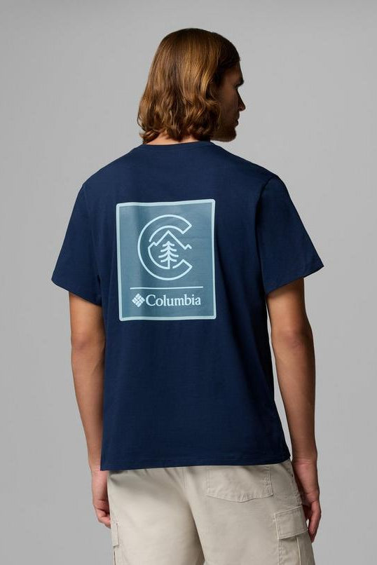 Person wearing a navy blue t-shirt with Columbia logo on the back against a gray background
