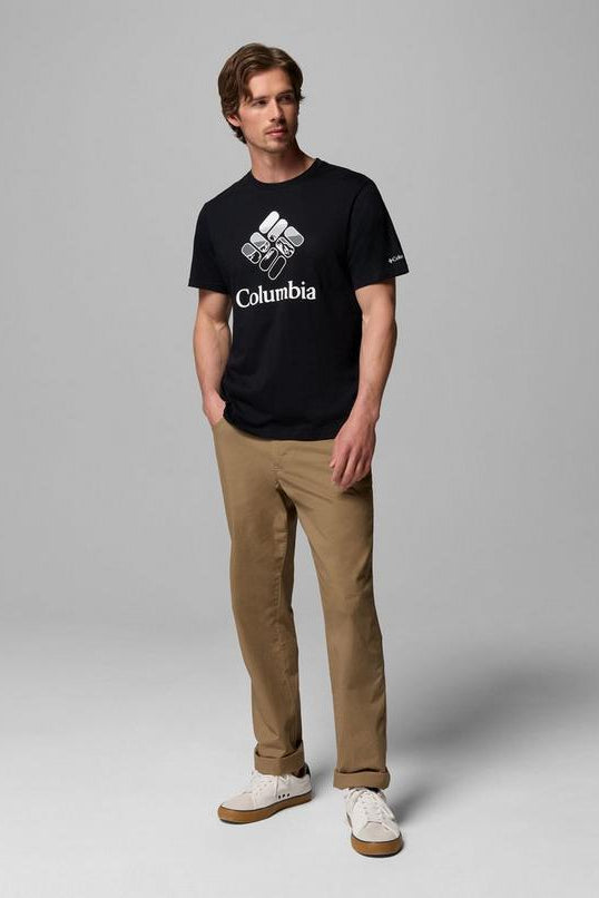 Person wearing a black Columbia t-shirt and beige pants on a gray background