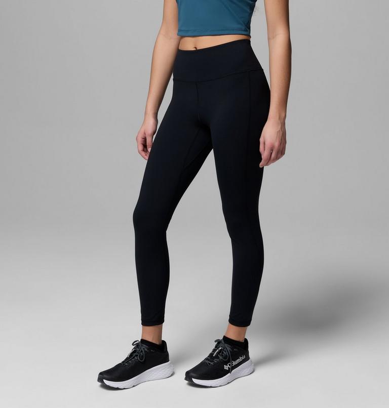 Person wearing black leggings and black sneakers on a gray background