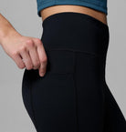 Person wearing black leggings with a gray background