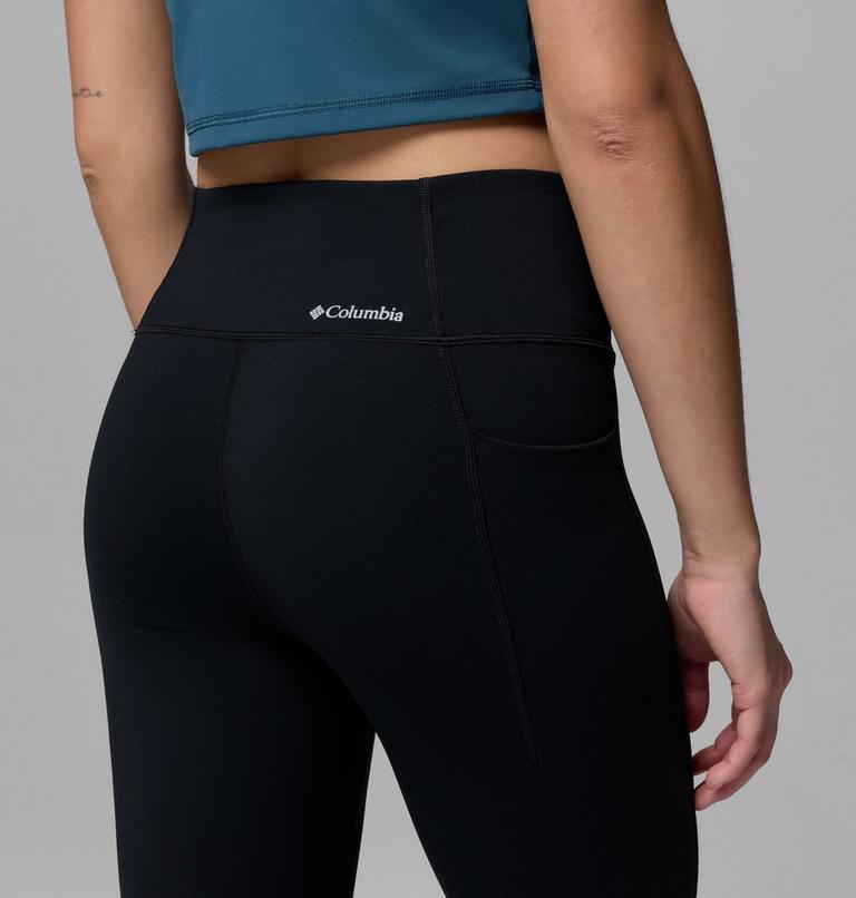 Person wearing black leggings with Columbia logo on a gray background