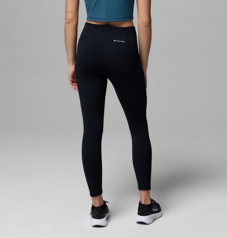 Person wearing black leggings with a visible brand logo on a gray background