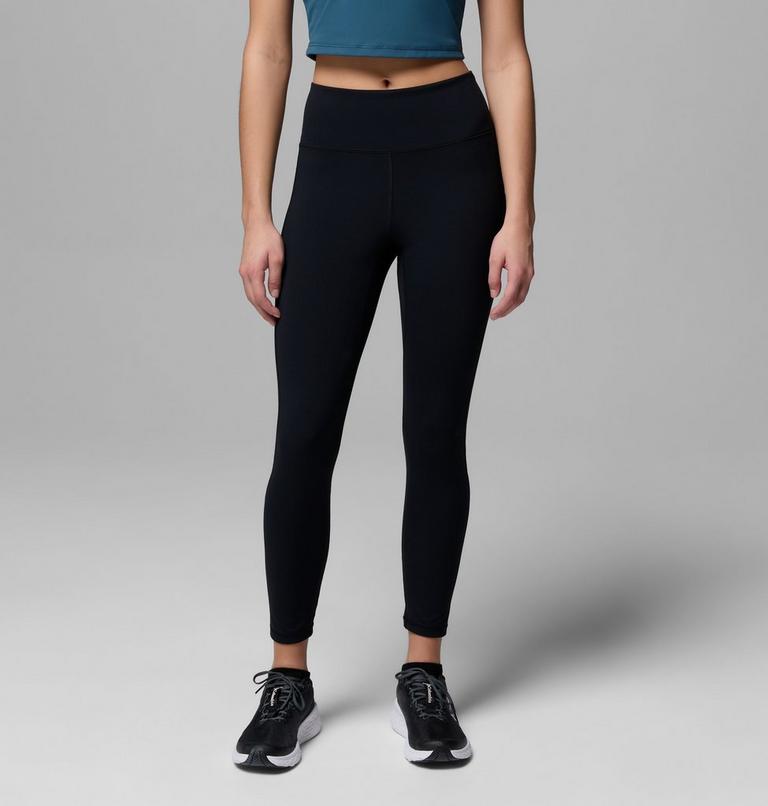 Person wearing black leggings and a blue top on a gray background