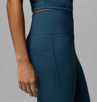 Teal athletic outfit with a focus on leggings against a gray background