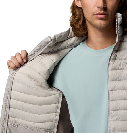 Man wearing a light gray puffer jacket over a light blue shirt on a white background