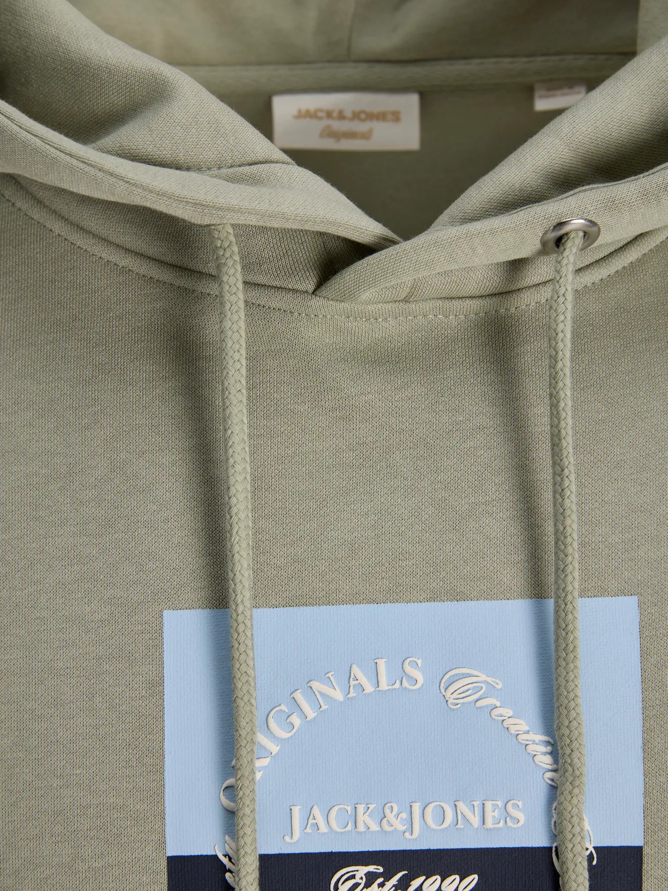 Close-up of a green hoodie with 'Jack & Jones' branding on the chest pocket.