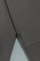 Close-up of the Titan Taupe sweatshirt side flag label and ribbed hem