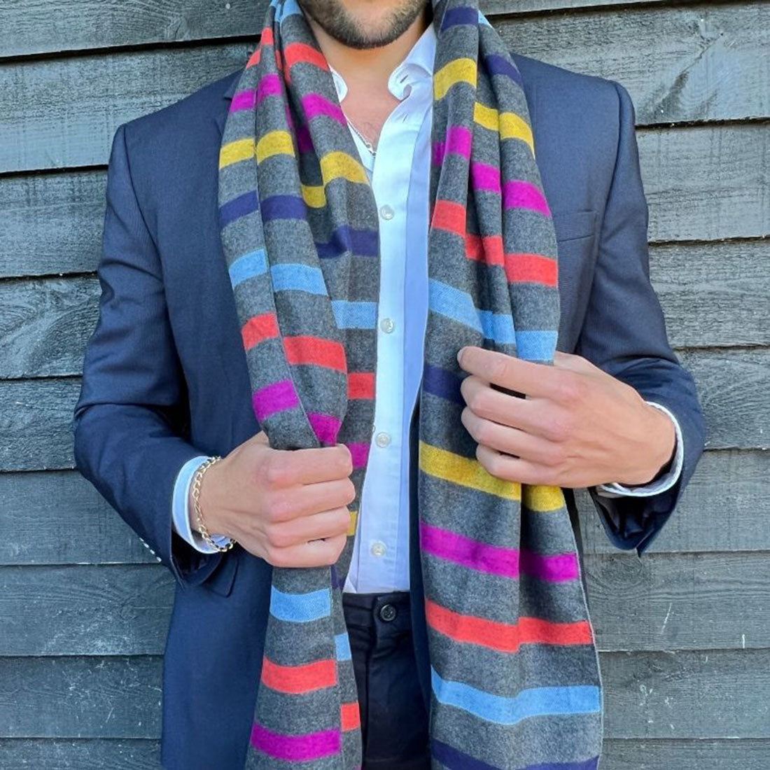 Man wearing a grey/multi stripe bamboo scarf over a navy blazer