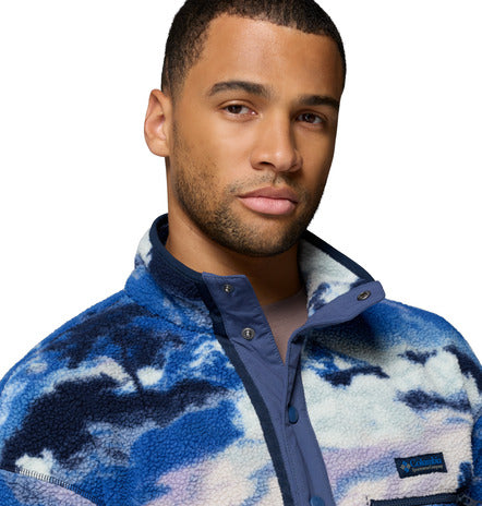 Man wearing a blue and white patterned jacket on a white background