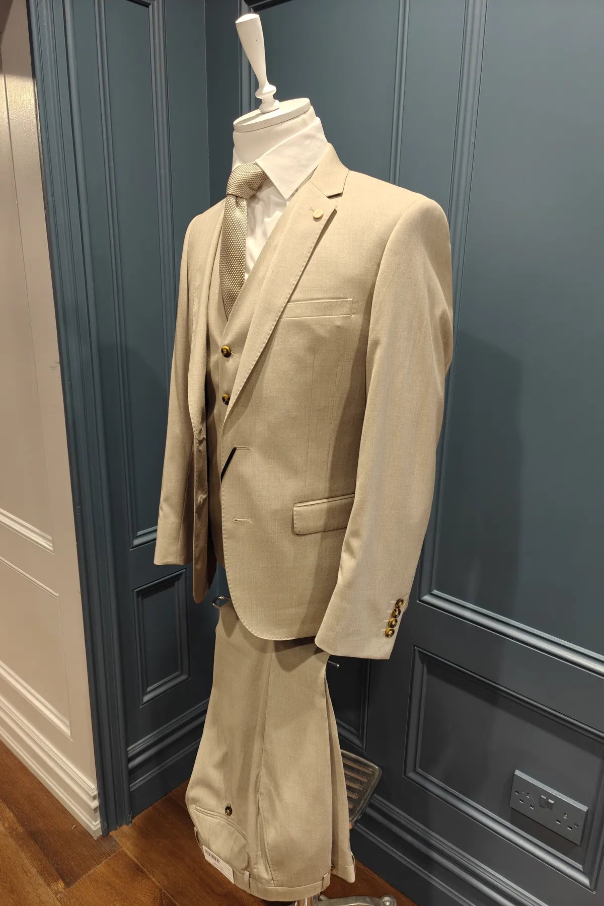 Kingsley walnut 3 piece suit from 6th Sense on a mannequin against a blue paneled wall.