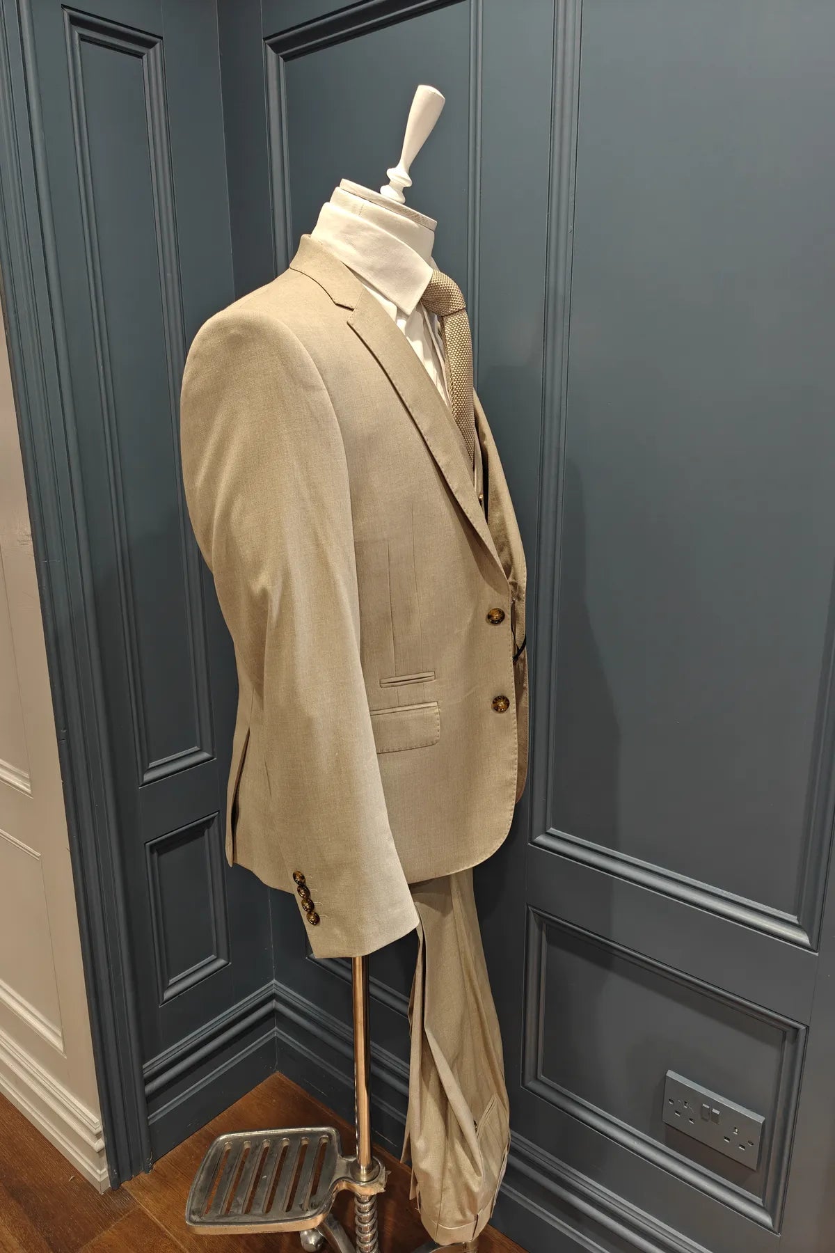 Kingsley walnut 3 piece suit from 6th Sense on a mannequin against a dark paneled wall. Angle view