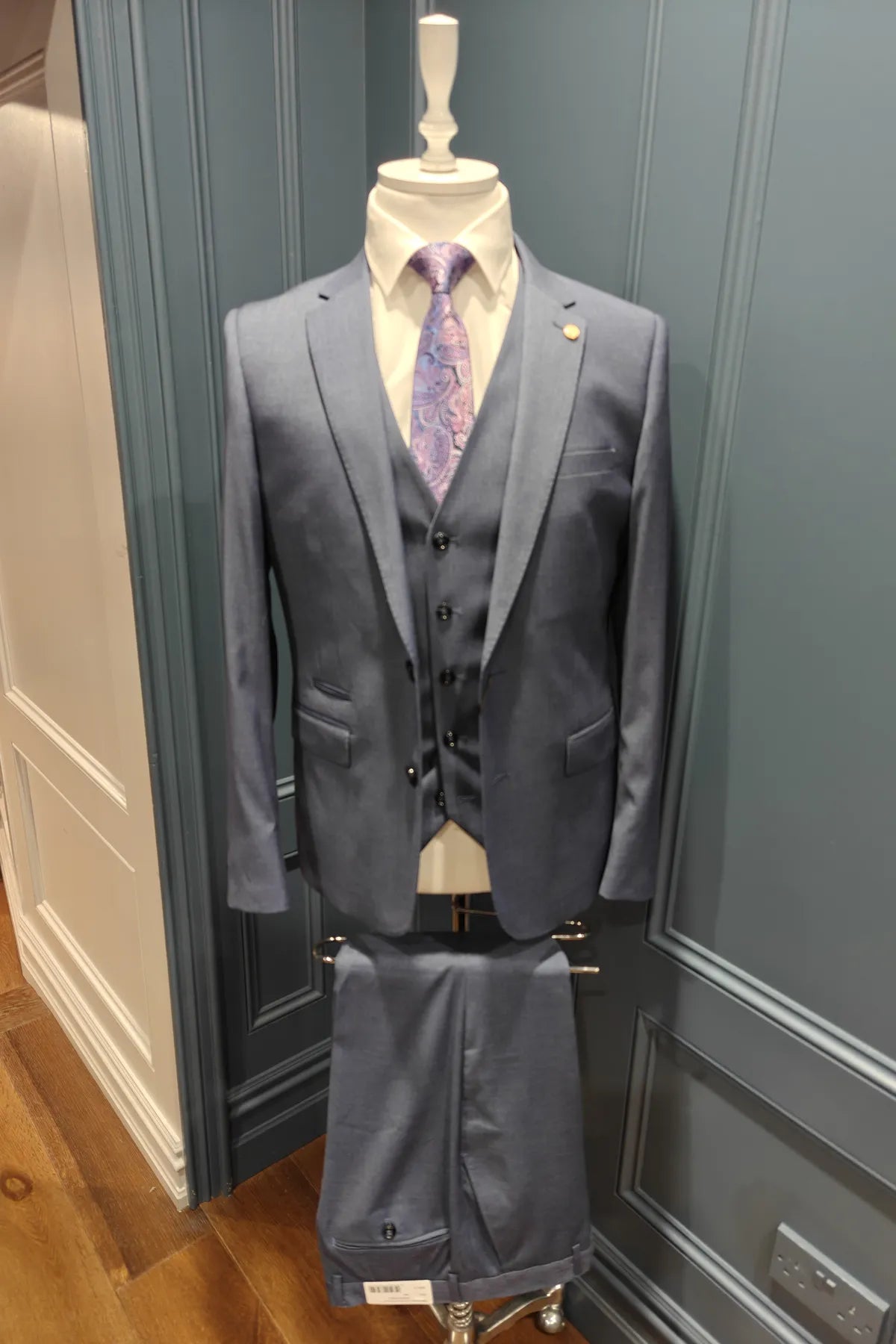 Kingsley Indigo suit with a tie on a mannequin against a gray wall.