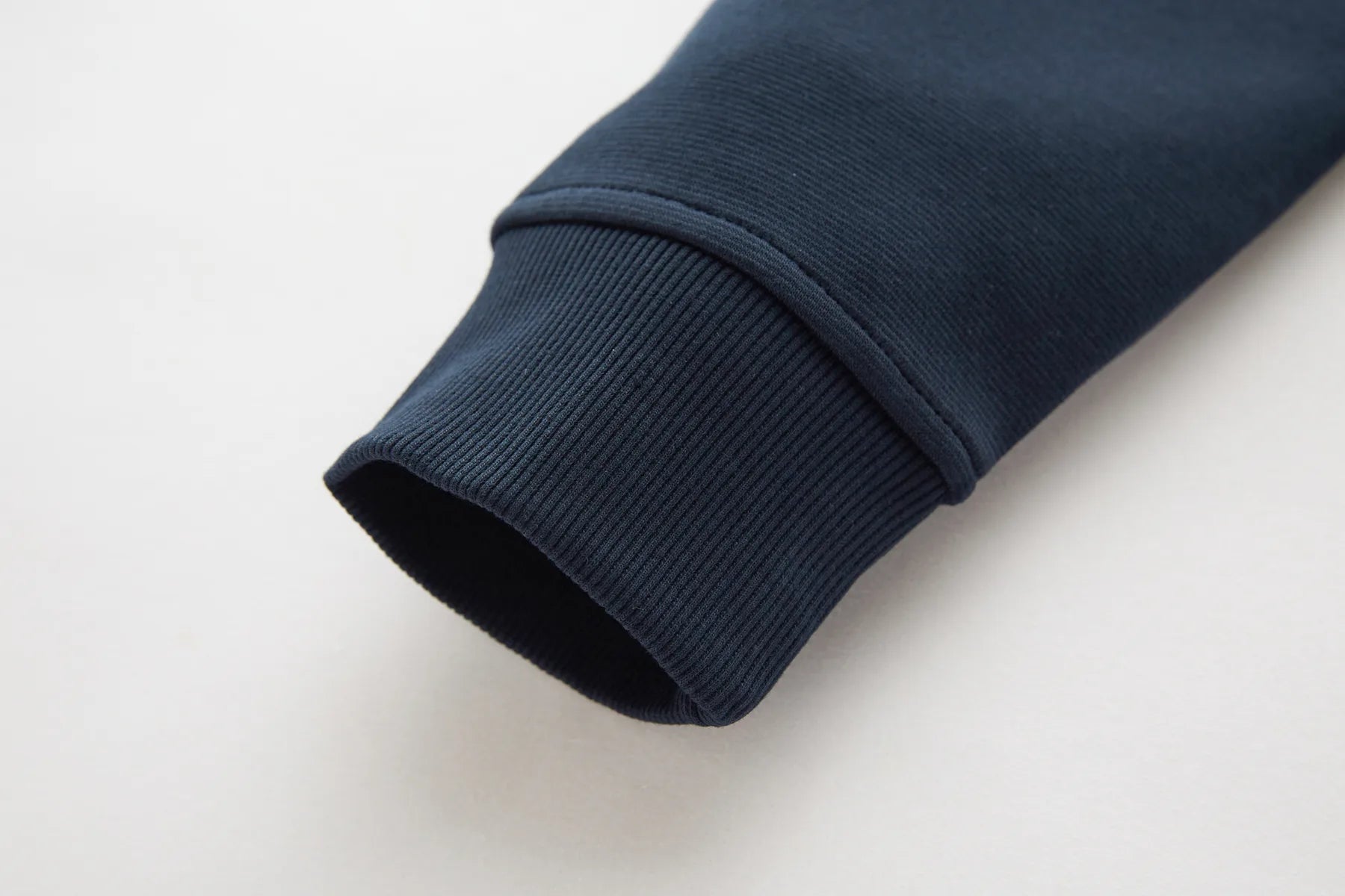 Close-up of a navy blue sleeve on a light gray background