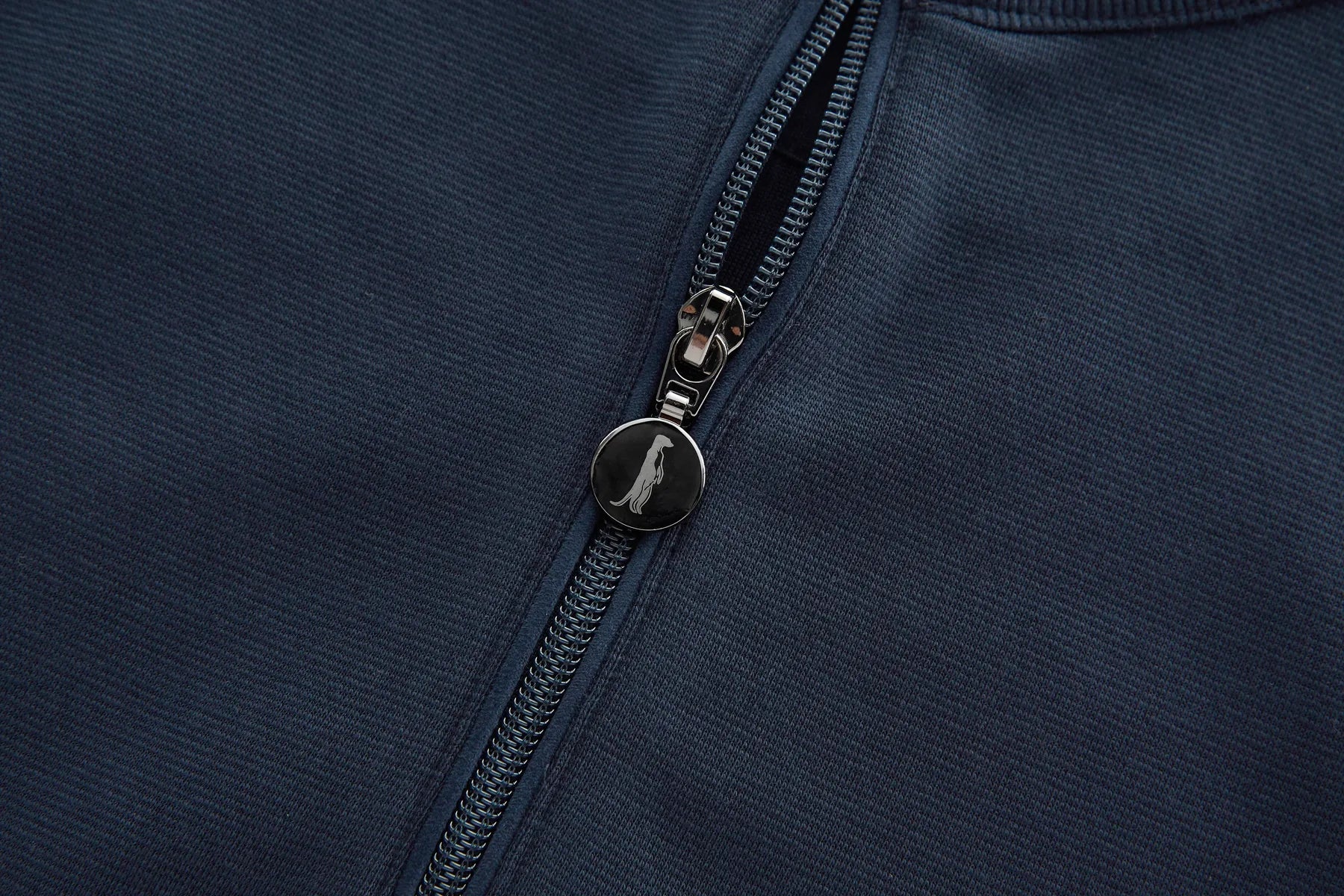 Close-up of a zipper on a dark blue fabric background