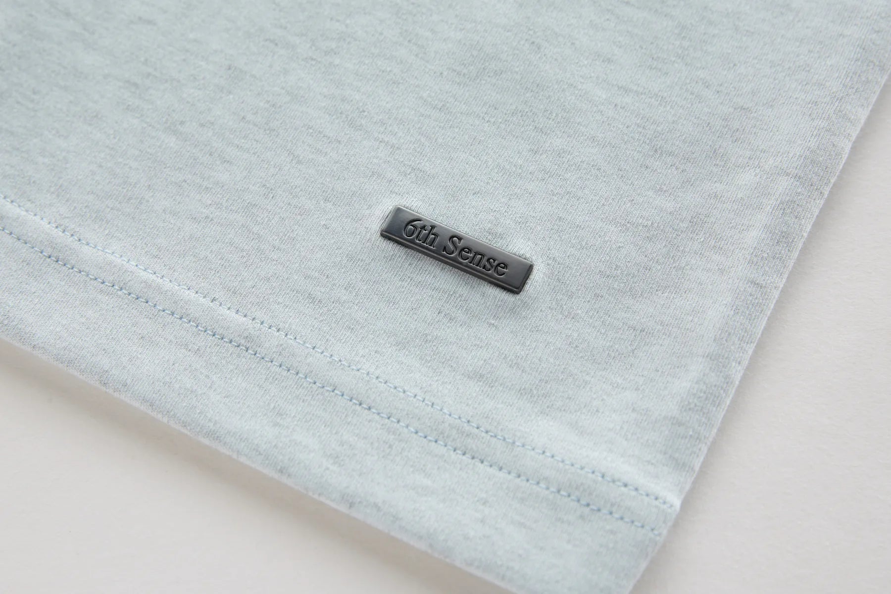 Ice fabric with a '6th Sense' label on a light beige background