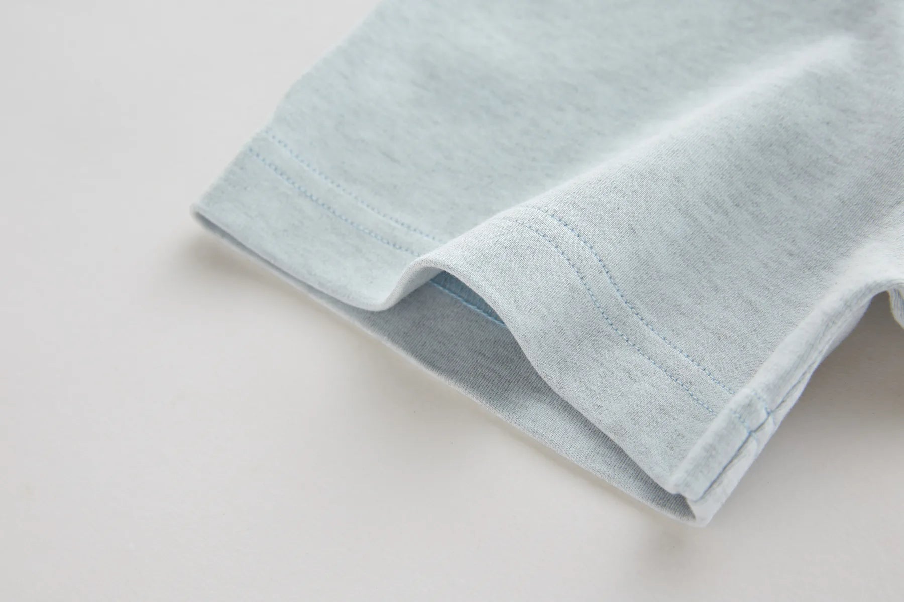 Folded light blue fabric on a white background