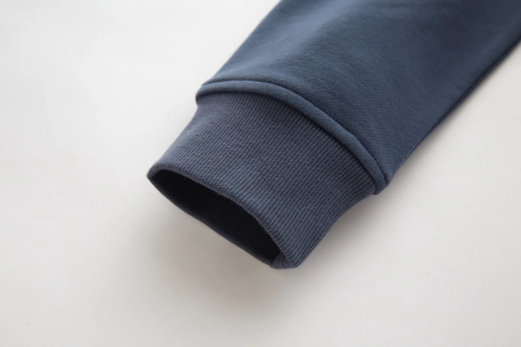 Close-up of a Sammy full zip turbulence jacket sleeve on a light gray background