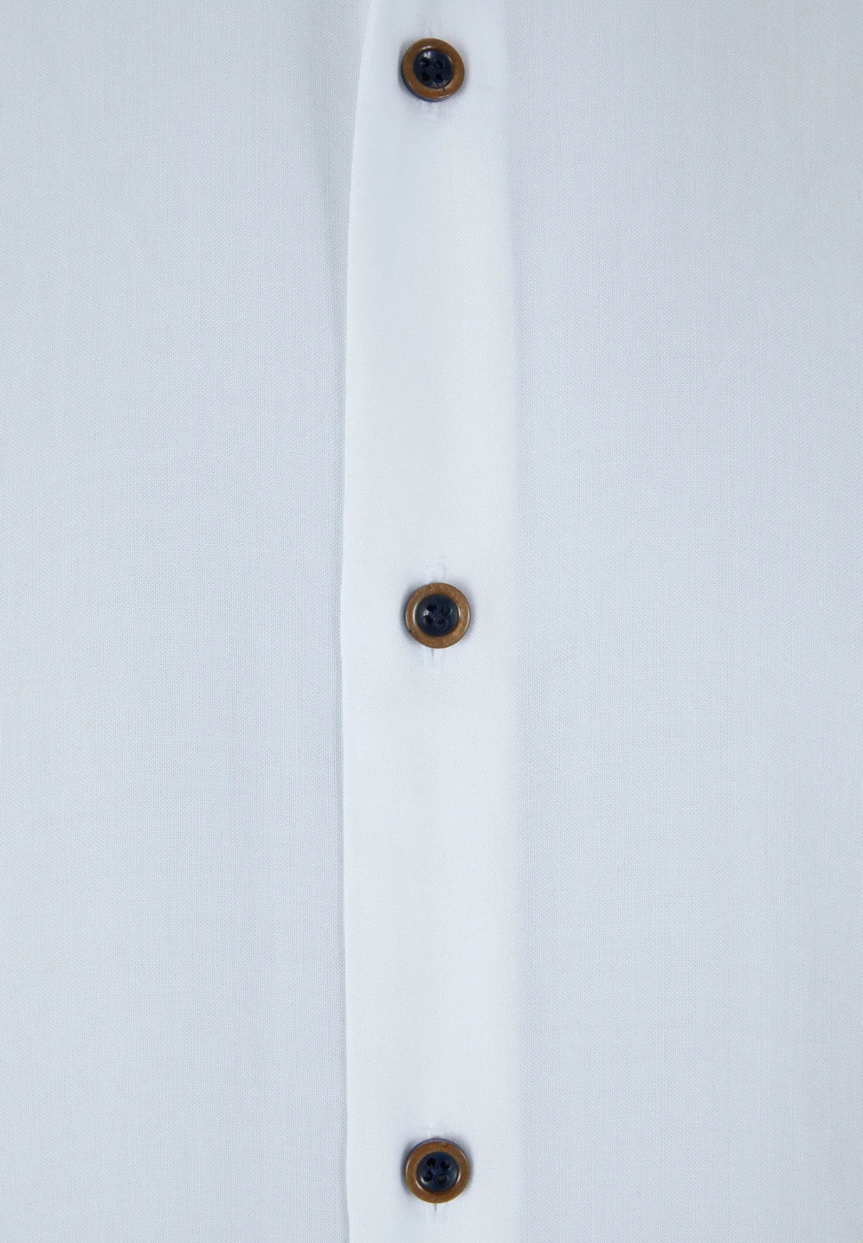 Close-up of a white shirt with brown buttons on a light gray background