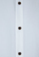 Close-up of a white shirt with brown buttons on a light gray background