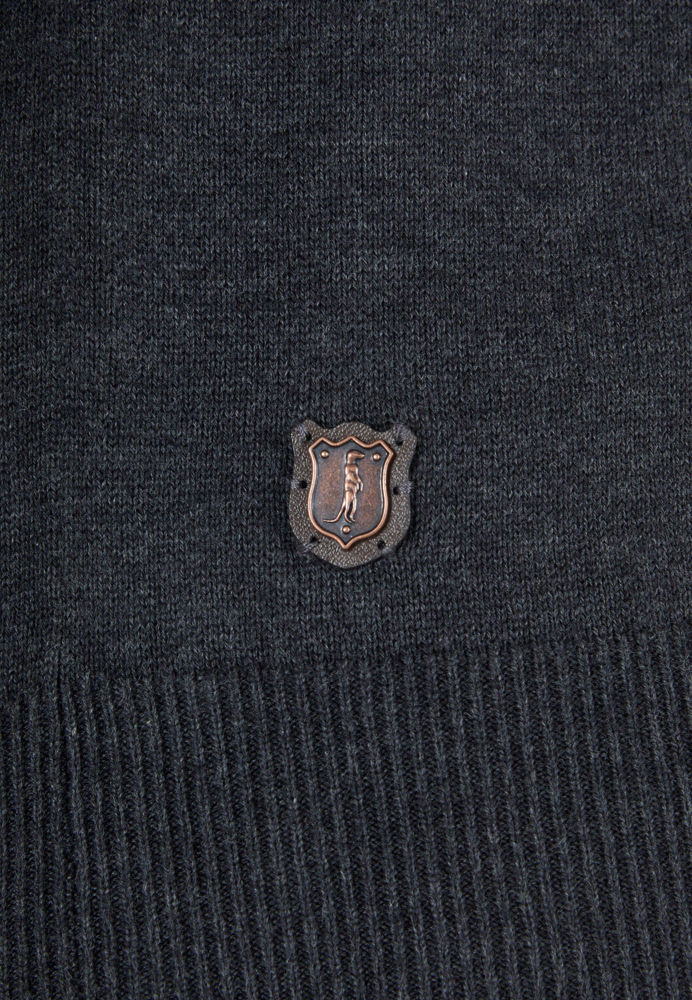 Close-up of a dark gray sweater with a logo on the chest.