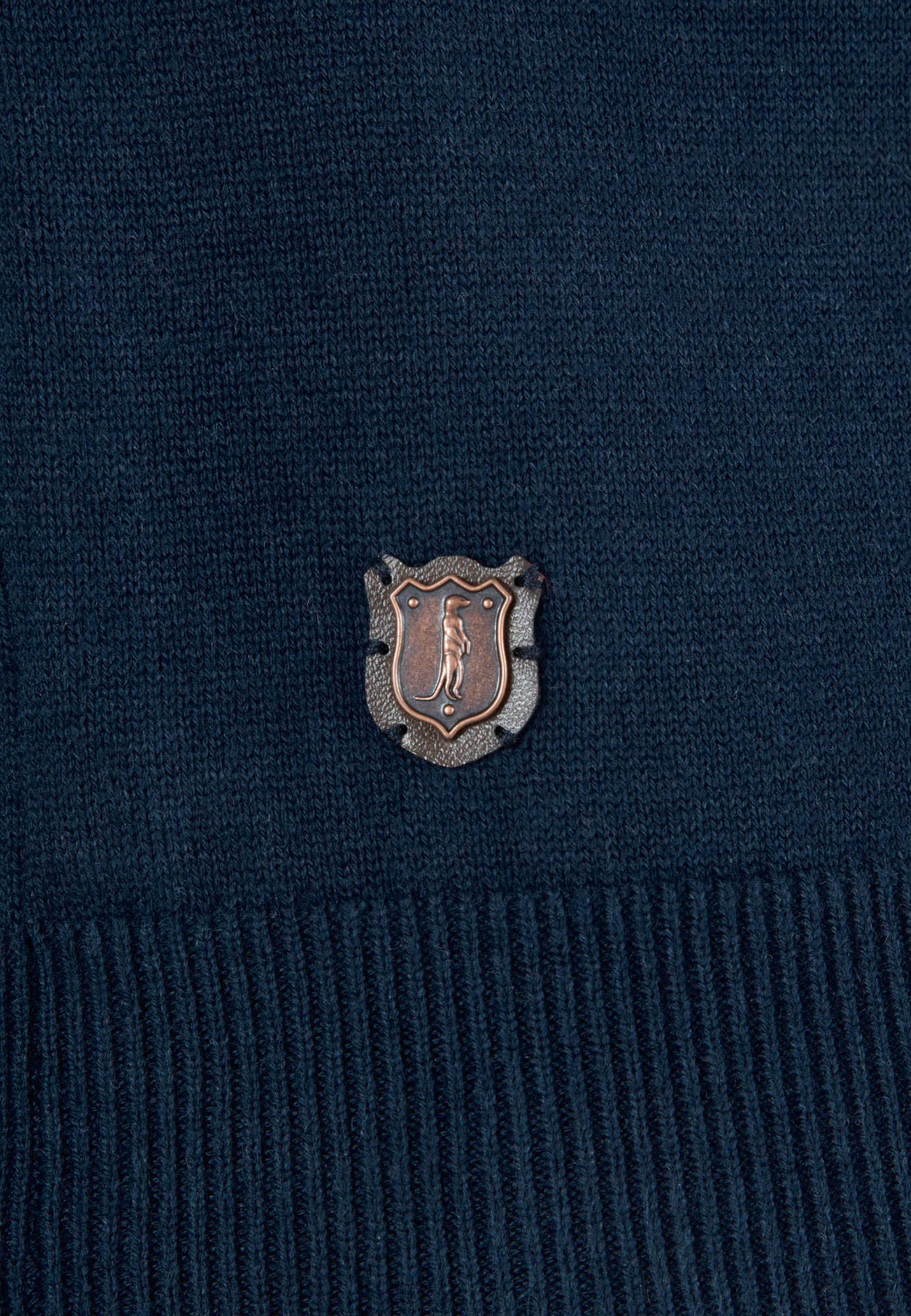 Navy sweater with a small embroidered logo on a dark background