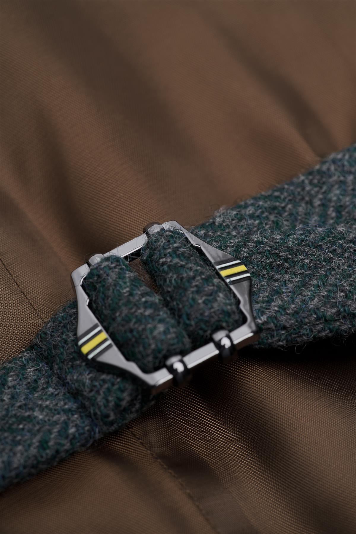 Close-up of a belt with a silver buckle on a brown fabric background