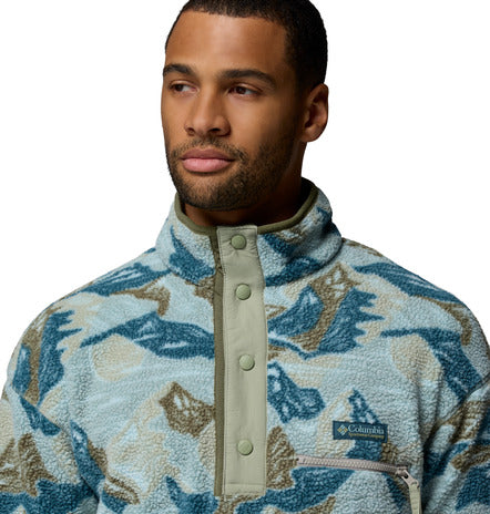 Man wearing a patterned fleece jacket with a visible brand logo on a white background