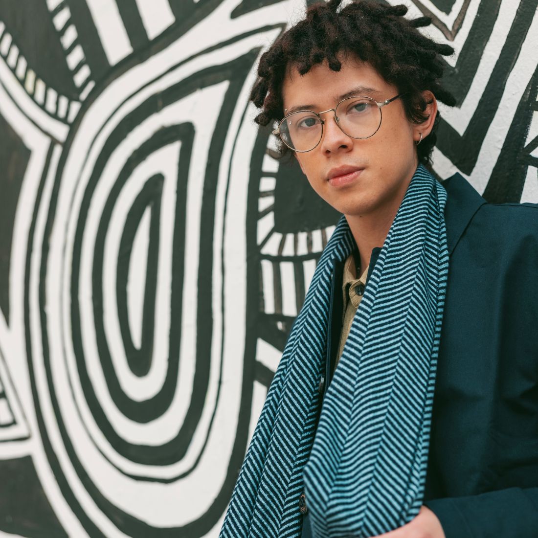 Man wearing Light Blue/Navy Herringbone Scarf over a navy coat
