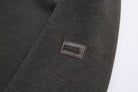 6th Sense woven label sewn on the sleeve of the peat 1/4 zip sweat.