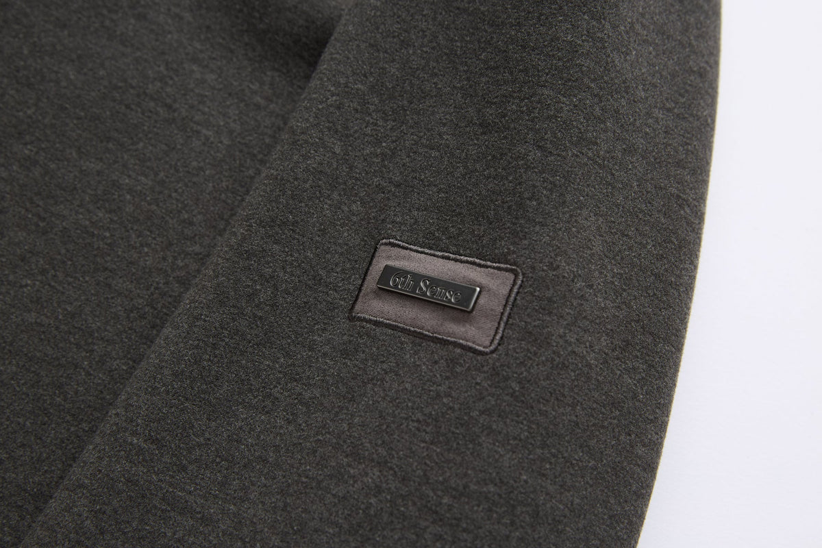 6th Sense woven label sewn on the sleeve of the peat 1/4 zip sweat.