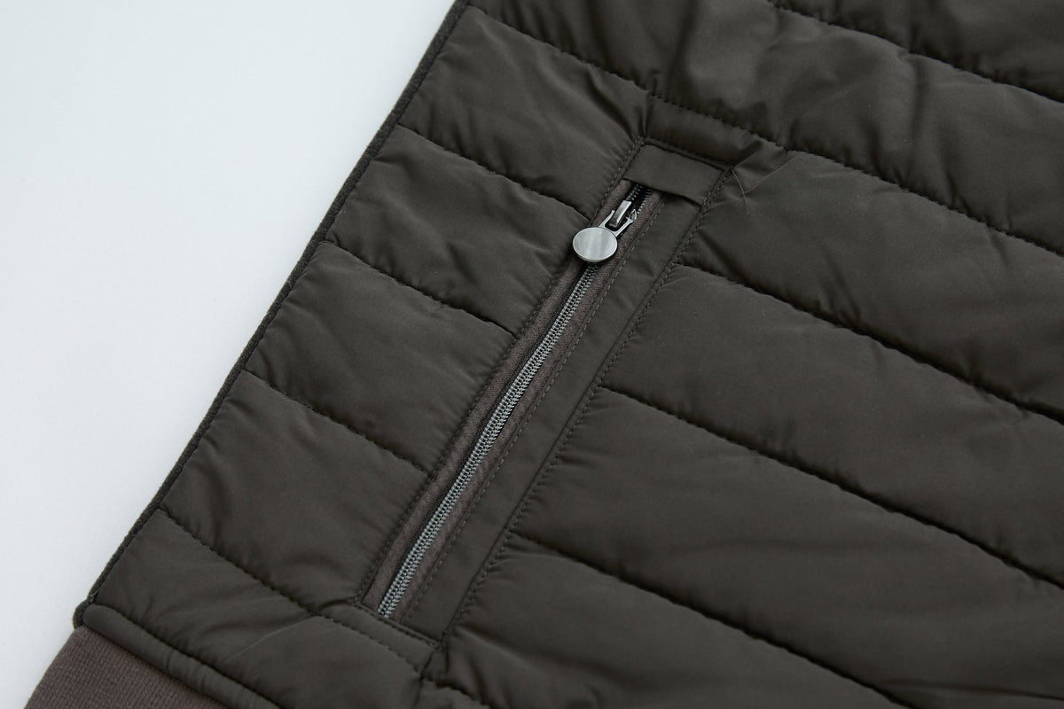 Side zip pocket on the 6th Sense Air Peat Gilet with round pull tab and horizontal quilt stitching.