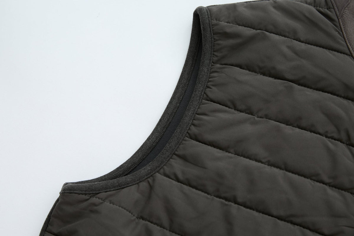 Armhole of the 6th Sense Air Peat Gilet finished with dark bound trim beside quilted peat panels.