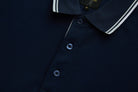 Close-up of the 6th Sense Astound Eclipse Polo in Eclipse, showing the placket, three buttons, ribbed collar with white tipping, and a branded size M label.