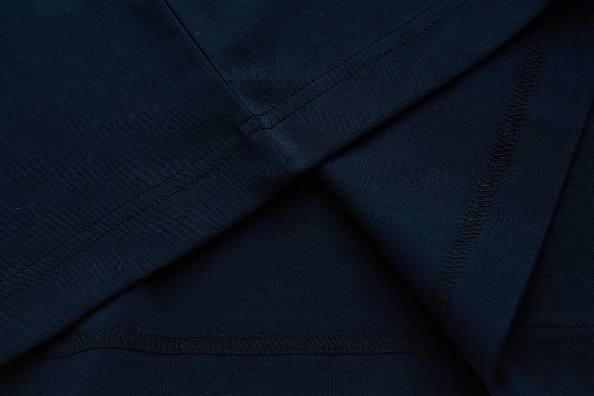 Close-up of the 6th Sense Astound Eclipse Polo in Eclipse, showing folded fabric with double stitching and overlock seams.