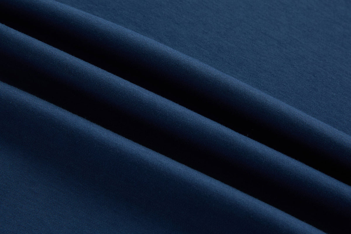 Folded blue fabric of the 6th Sense Astound Ensign Polo showing subtle texture.
