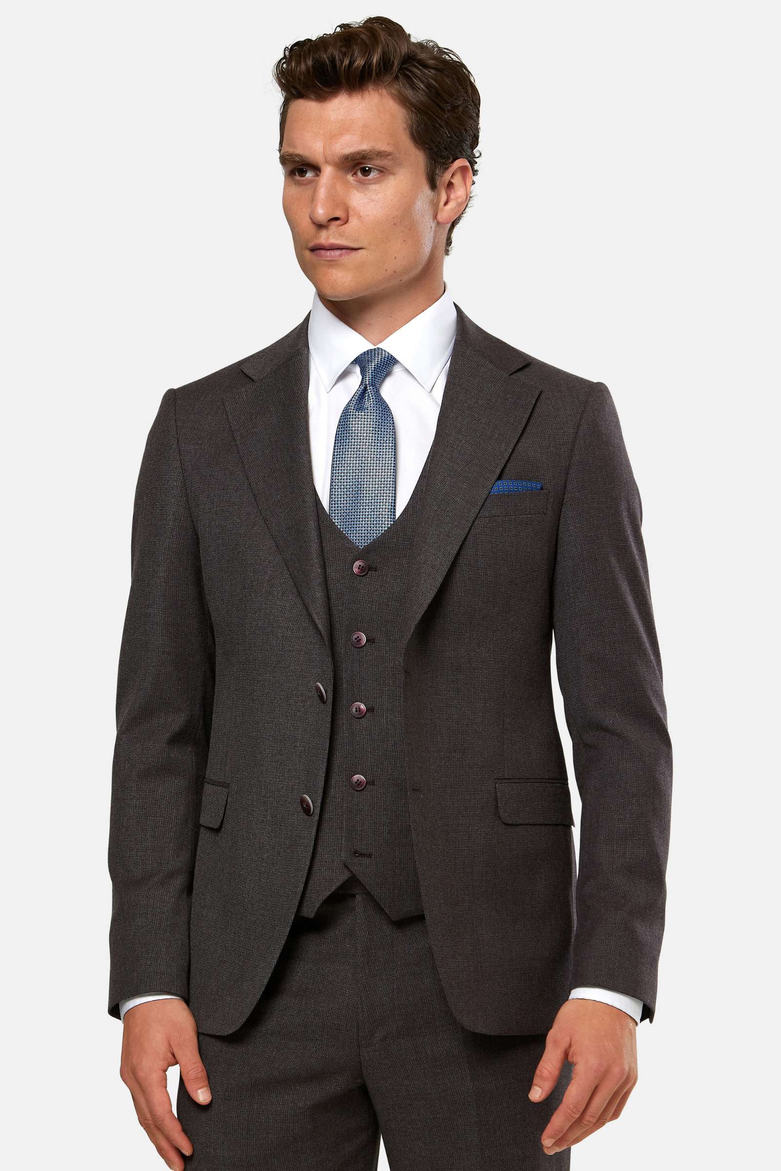 Man wearing a burgundy suit with a blue tie on a white background