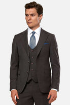 Man wearing a burgundy suit with a blue tie on a white background