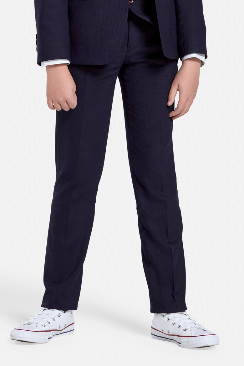 Young boy wearing a navy suit trousers  on a white background