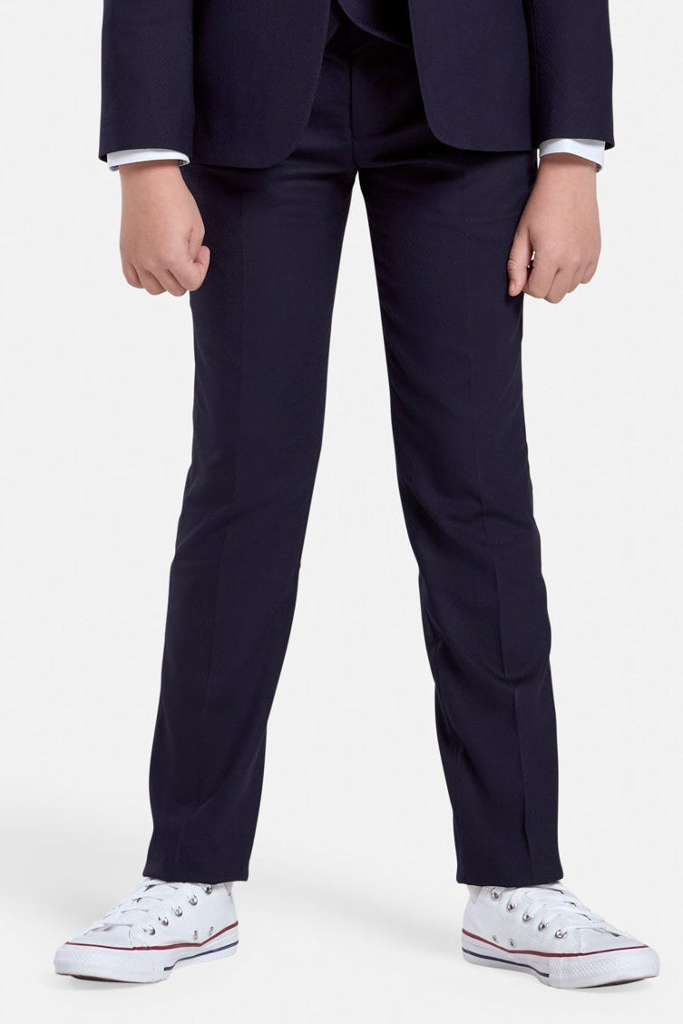 Young boy wearing a navy suit trousers  on a white background