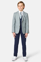 Young boy wearing a sage green checkered blazer with a white shirt and blue tie on a white background