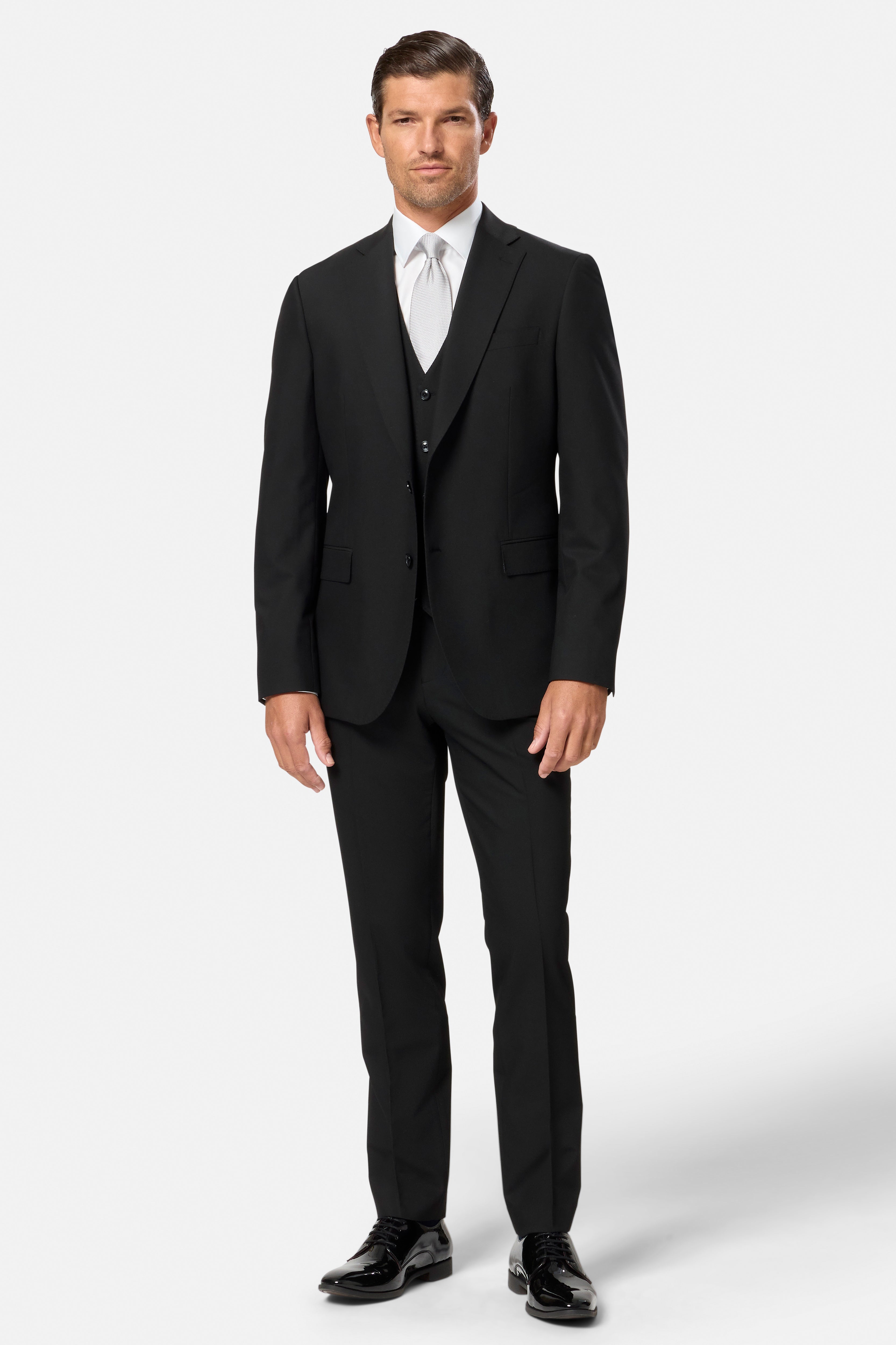 Man wearing a black suit with a white shirt on a white background