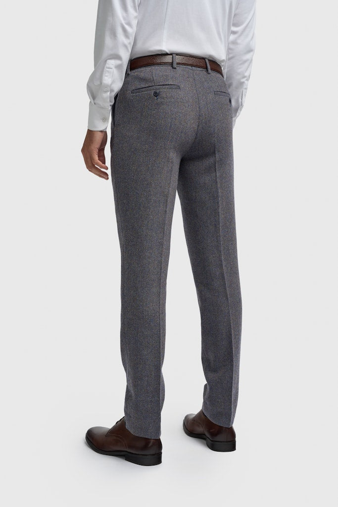 Gray suit pants worn by a person on a white background