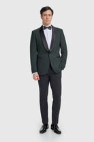 Man wearing a formal olive tuxedo with a white shirt and black bow tie on a white background