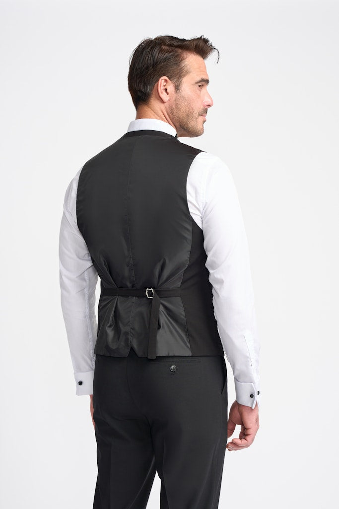 Man wearing a black double breasted waistcoat over a white shirt on a white background-Back view