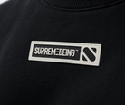 Close-up of the Supreme Being chest badge on the Element black sweatshirt