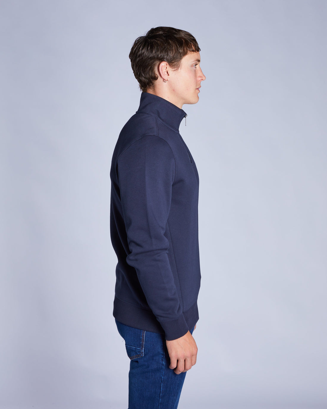 Man wearing a navy blue sweat on a light gray background