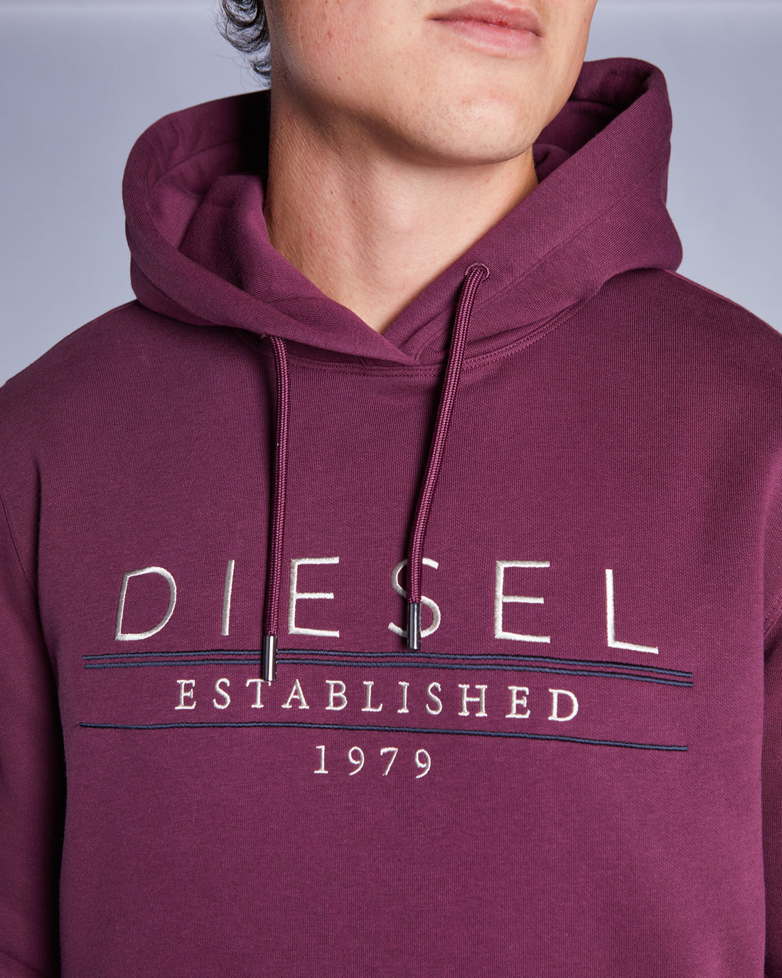 Maroon hoodie with 'Diesel Established 1979' text on a plain background
