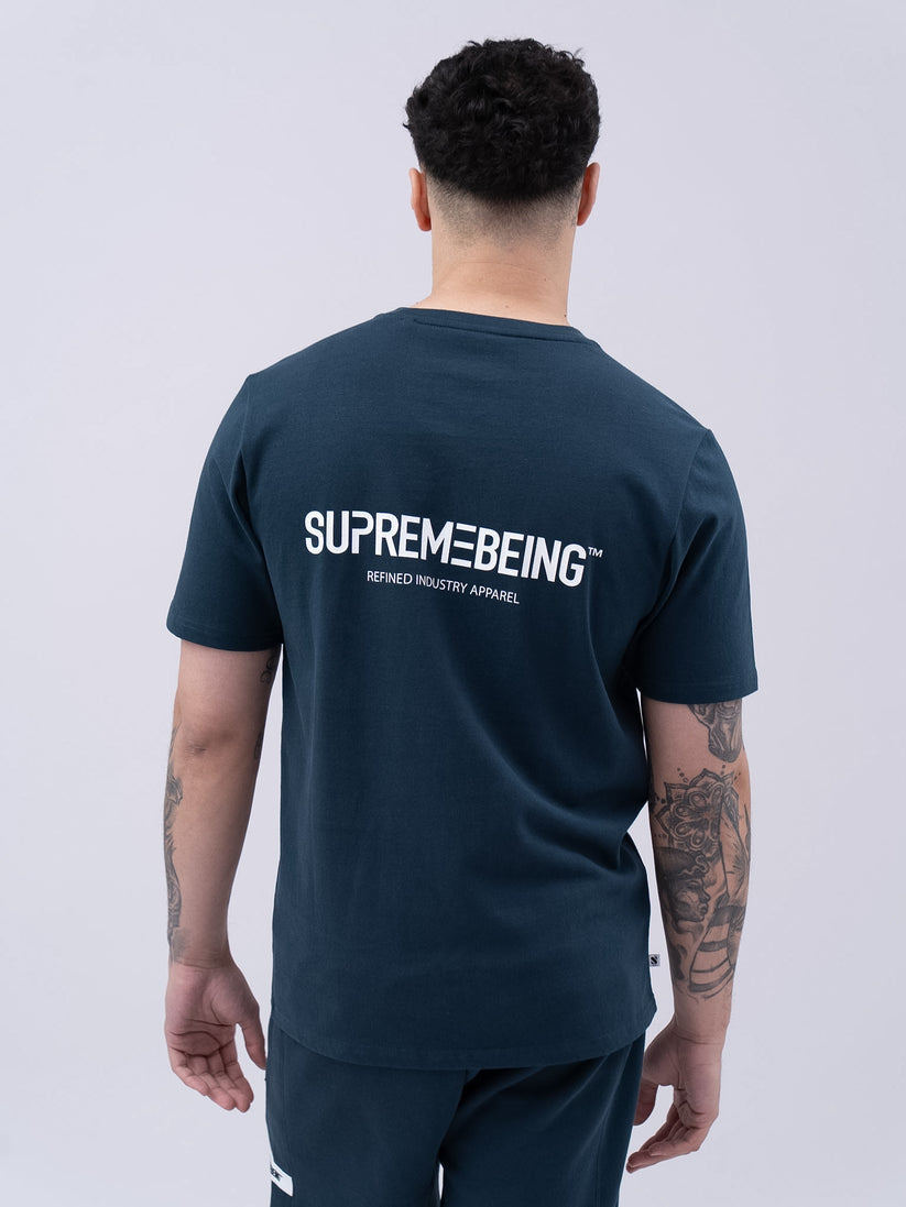 Person wearing a navy blue t-shirt with 'Supreme Being' logo on the back against a white background